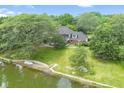 Aerial view of backyard leading to lake with lush green landscaping and mature trees at 10817 Lakeview Dr, Carmel, IN 46033