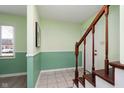 Bright foyer featuring a staircase, tile flooring, and mint green accent walls at 1138 Canterbury S Sq, Indianapolis, IN 46260
