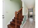 Elegant staircase with dark wooden railing and mint green accent walls leading to the second floor at 1138 Canterbury S Sq, Indianapolis, IN 46260