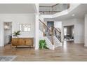 Expansive foyer with hardwood floors, staircase, and console table, creating a grand entrance with a view to the kitchen at 13770 Marylou Dr, Carmel, IN 46074