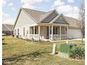 View of a well-maintained brick home with a covered porch and manicured lawn at 1382 Redstone Dr, Avon, IN 46123
