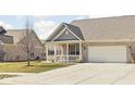 Charming brick home featuring an attached two-car garage and a cozy front porch at 1382 Redstone Dr, Avon, IN 46123