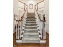 Grand foyer showcasing a staircase with wood railings, white trim, and neutral carpeting at 1409 S Harmony Trl, Greenfield, IN 46140
