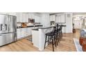 Modern kitchen with white cabinets, granite countertops, stainless steel appliances, and a breakfast bar with seating at 15104 Midland Ln, Noblesville, IN 46062