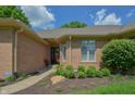 Inviting front entrance with a brick facade, manicured garden beds, and a charming entryway at 1738 Pathway S Dr, Greenwood, IN 46143