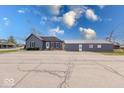 Exterior shot of blue home with a large grey detached garage or outbuilding at 1828 Central Ave, Columbus, IN 47201