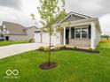 Charming single-story home showcasing a three-car garage, a covered porch, and a well-manicured lawn at 2254 Oakmont Dr, Plainfield, IN 46168