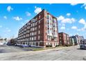 Brick apartment building featuring symmetrical design with large windows and a parking area at 230 E 9Th St # Apt 405, Indianapolis, IN 46204