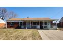 Charming brick home with a covered porch and well-manicured lawn, creating curb appeal at 2317 Courtney Rd, Indianapolis, IN 46219