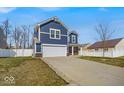 Side view of a two-story blue home with a white garage door and trim on a cloudy day at 3602 Shepperton Blvd, Indianapolis, IN 46228