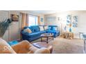 Cozy living room featuring a comfortable blue sofa, artwork, and carpeted floors at 4113 Gambel Rd, Indianapolis, IN 46221