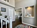 Foyer with hardwood floors, an open staircase and a niche on a gray painted wall at 4309 Worchester Ct, Carmel, IN 46033