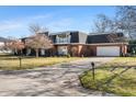 Side view of brick home featuring second story balcony, mature trees and green lawn at 4501 N Wheeling Ave # 6A - 201, Muncie, IN 47304