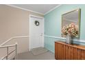 Inviting foyer with front door, wood cabinet, mirror, and colorful floral arrangement at 4501 N Wheeling Ave # 6A - 201, Muncie, IN 47304