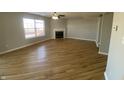 Spacious living room featuring hardwood floors, a ceiling fan, a fireplace, and a large window at 518 Waterford Way, Danville, IN 46122