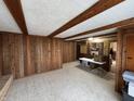 Inviting living room with wood-paneled walls and exposed beam ceiling, offering a rustic feel at 5207 N Sadlier Dr, Indianapolis, IN 46226