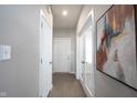 Neutral hallway featuring tile floors, white doors, and decorative wall art, leading to various rooms at 5462 Wood Spg Ln, McCordsville, IN 46055