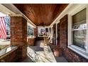 Inviting brick porch with wood ceiling, fan, and seating, creating a relaxing outdoor space at 6162 Carrollton Ave, Indianapolis, IN 46220