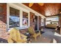 Charming porch with brick columns, ceiling fan, and cozy seating, perfect for enjoying the outdoors at 6162 Carrollton Ave, Indianapolis, IN 46220