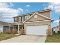 Charming two-story home featuring a brick and siding facade, black shutters, and an attached two-car garage at 6302 Emerald Field Way, Indianapolis, IN 46221