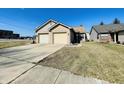 Single story home with a large driveway leading to an attached 2-car garage and a well-manicured front lawn at 734 W 9Th St, Greenfield, IN 46140