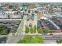 An aerial view shows the property featuring two towers, lush trees, and parking areas at 802 N Meridian St # 204, Indianapolis, IN 46204
