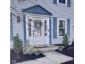 Close-up view of the front door with wreath and detailed trim, complemented by manicured landscaping at 8271 Shattuck Dr, Avon, IN 46123