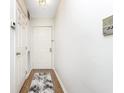 Clean entryway with a white door, leading into the home with a small rug on hardwood flooring at 8820 Yardley Ct # 101, Indianapolis, IN 46268