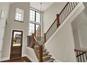 Grand foyer featuring high ceilings, a staircase with wooden banister, and natural light streaming through large windows at 908 Oak Terrace Rd, Westfield, IN 46074