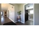 Hallway with wood floors, leading to a laundry room with modern appliances at 9161 Warwick Rd, Indianapolis, IN 46240