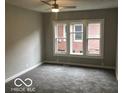 Well-lit bedroom boasts neutral tones, new carpet, and large windows offering ample natural light at 923 N Denny St, Indianapolis, IN 46201