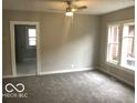 Bright living area features fresh paint, new carpet, large windows, and ceiling fan at 923 N Denny St, Indianapolis, IN 46201