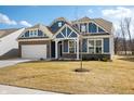 Lovely home showcasing blue siding, brick accents, a covered porch, and well-maintained front yard at 9839 Canyon Ln, Pendleton, IN 46064