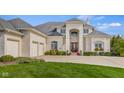 Beautiful white brick home with a grand entrance, manicured lawn and three-car garage at 995 Westlake Hills Dr, Columbus, IN 47201