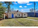 Charming single-story home featuring a bright blue door, neutral siding, and a well-maintained front yard at 1023 Helen Dr, Indianapolis, IN 46240