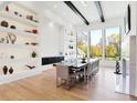Open-concept dining room featuring natural light, hardwood floors and display shelves at 10351 Windemere Blvd, Carmel, IN 46032