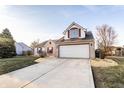 Charming two-story home showcasing manicured lawn, brick and vinyl siding, and a two-car garage at 10893 Cannonade Ct, Indianapolis, IN 46234