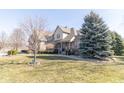 Beautifully landscaped front yard with mature trees framing a charming brick home at 1115 Morningside Ct, Greenfield, IN 46140