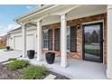 Inviting front porch with classic columns, black accents, and neatly trimmed bushes showcasing charm and style at 11907 Ledgestone Cir, Fishers, IN 46037
