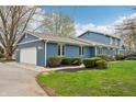 Side of a blue home with a two-car garage, showcasing well-maintained landscaping and classic suburban design at 1250 W 141St St, Carmel, IN 46032