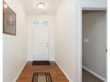 Bright foyer showcasing wood floors, a white door with sidelight windows, and neutral paint at 1590 Blackthorne N Trl, Plainfield, IN 46168