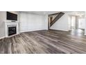 Open-concept living room with fireplace, stylish wood-look floors, and a staircase at 2352 Somerset Cir, Franklin, IN 46131