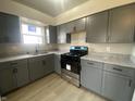 A kitchen with gray cabinets, stone countertops, and stainless steel oven appliance at 238 N 7Th Ave, Beech Grove, IN 46107