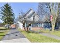 Charming two-story home with an American flag displayed, along with an inviting front porch and long driveway at 302 S Sherman Dr, Indianapolis, IN 46201