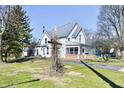 Charming two-story home with brick enclosed porch with many trees in the large yard at 302 S Sherman Dr, Indianapolis, IN 46201
