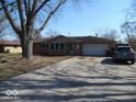 Single-story brick home with attached garage and long driveway, perfect for suburban living at 32 S Elma St, Anderson, IN 46012