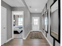Entry hallway featuring wood floors, gray walls, decorative mirrors, and view into a bedroom with natural light at 3871 Flora Dr, Franklin, IN 46131