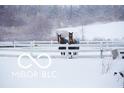 Snowy landscape featuring two horses standing near a white fence in a winter setting at 4031 N Banta Rd, Bargersville, IN 46106