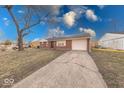 A well-maintained brick home with an attached garage and a long concrete driveway at 4132 Richelieu Rd, Indianapolis, IN 46226