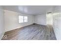 Spacious living room with new laminate flooring, natural light, and fresh paint at 4132 Richelieu Rd, Indianapolis, IN 46226